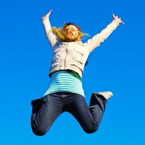 girl jumping against blue sky background