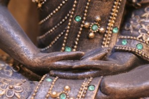 close up of metal statue's hands folded in lap