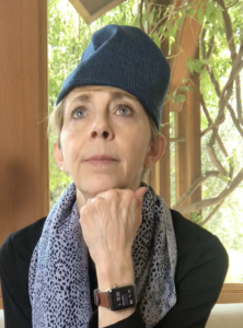 Martha Beck resting head on hand in a thinking pose wearing a loose-fitting hat