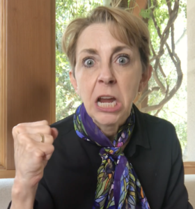 Martha Beck looking angry and shaking her fist at the camera