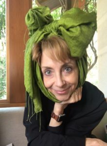 Martha Beck wearing a green scarf around her head in a big bow looking into the camera
