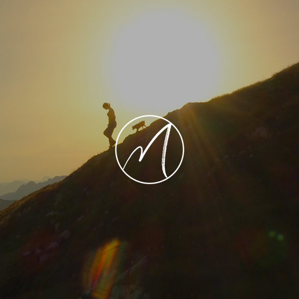 person and dog climbing down mountainside at sunrise with Martha Beck logo