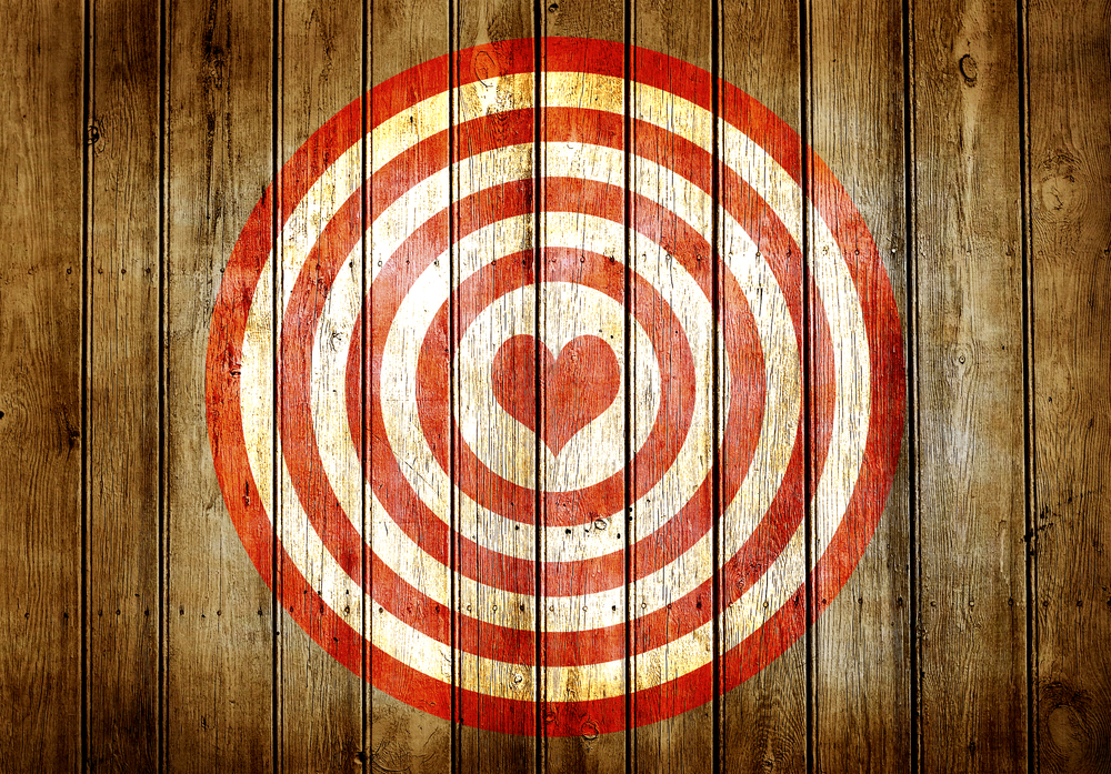 red and white bullseye with heart in the middle on wood wall