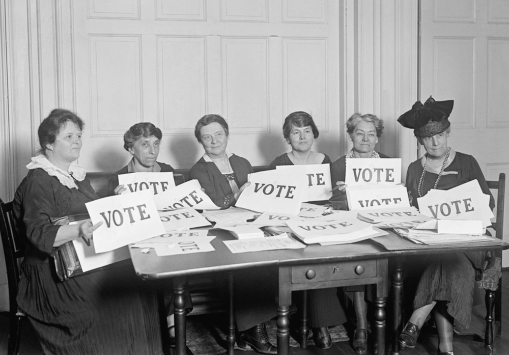 black and white photo of six suffragettes holding signs that say Vote