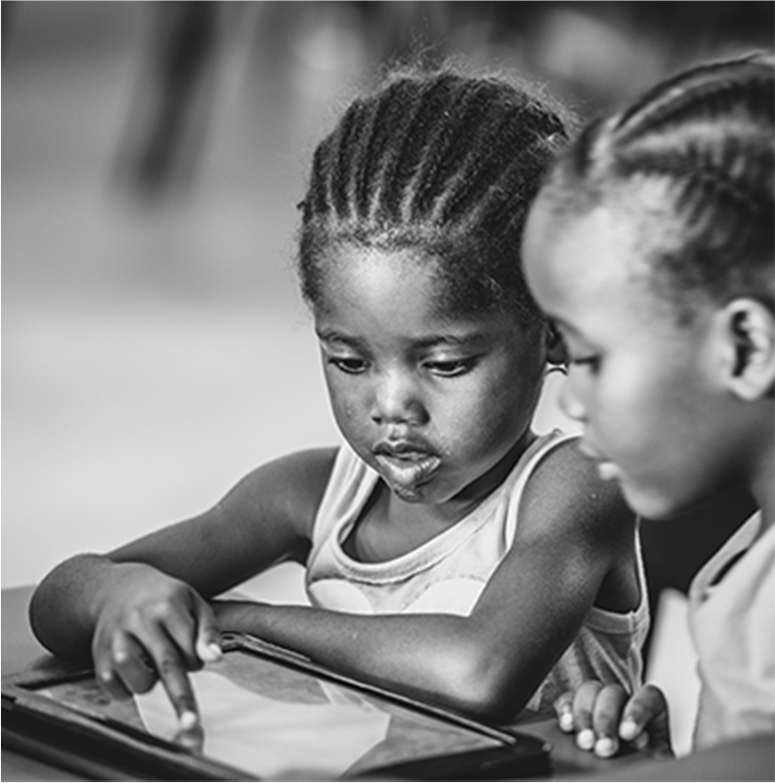 black and white image of two small children using an iPad