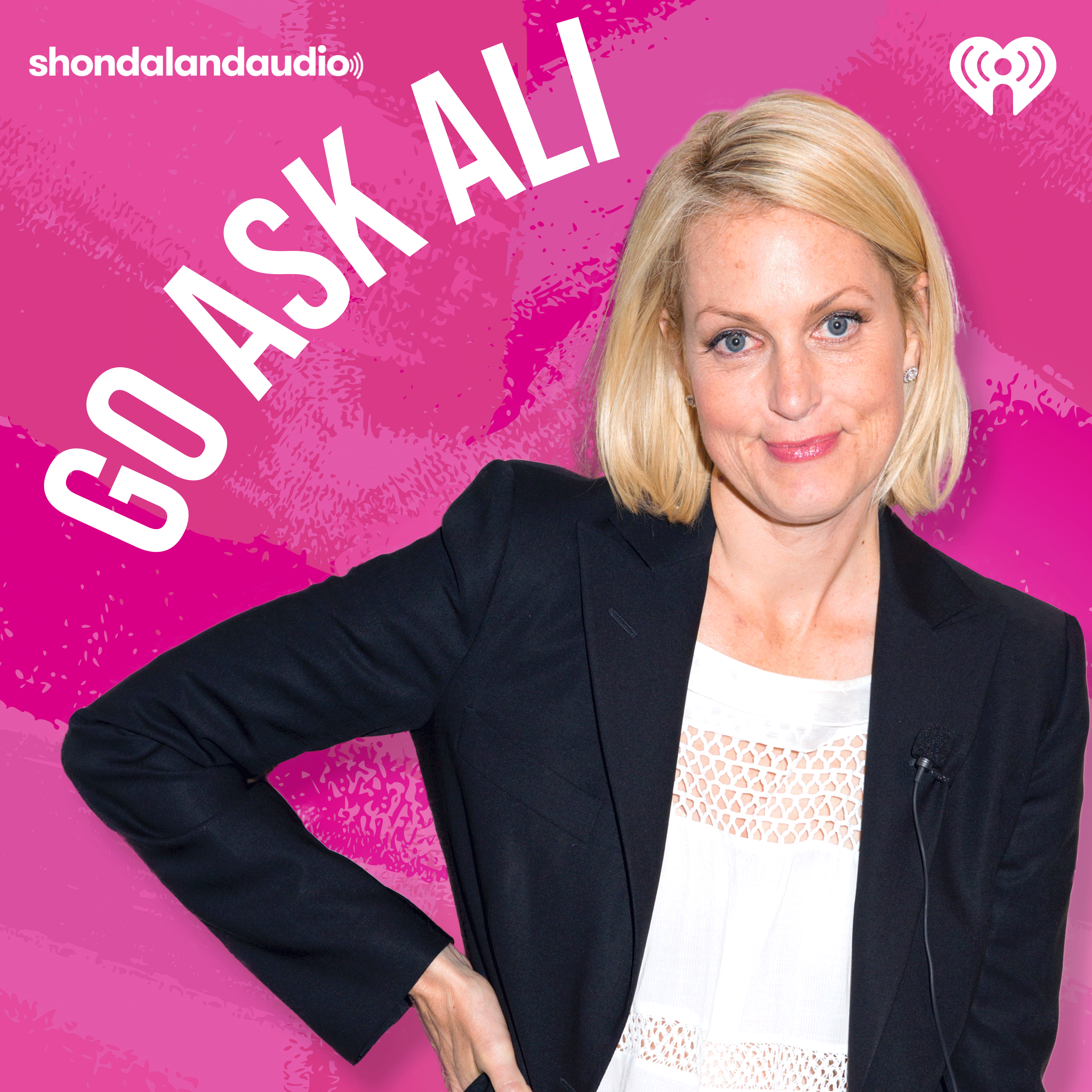 Ali Wentworth with her hand on her hip and a bright pink background.